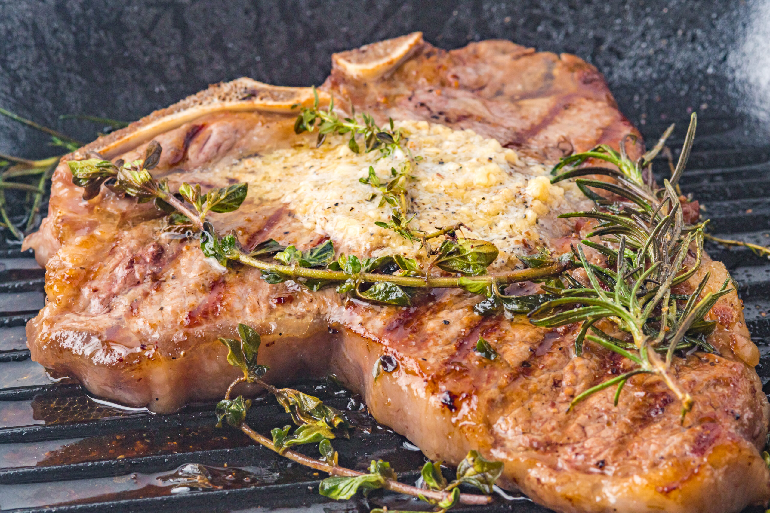 T bone steak in a grill frying pan topped with butter