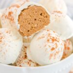 Pumpkin Spice Cheesecake Bites in a bowl with one cut in half to show filling