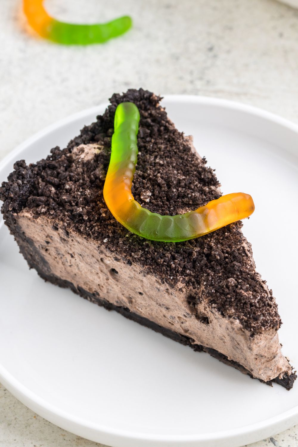 slice of dirt pie on plate with a gummy worm on top