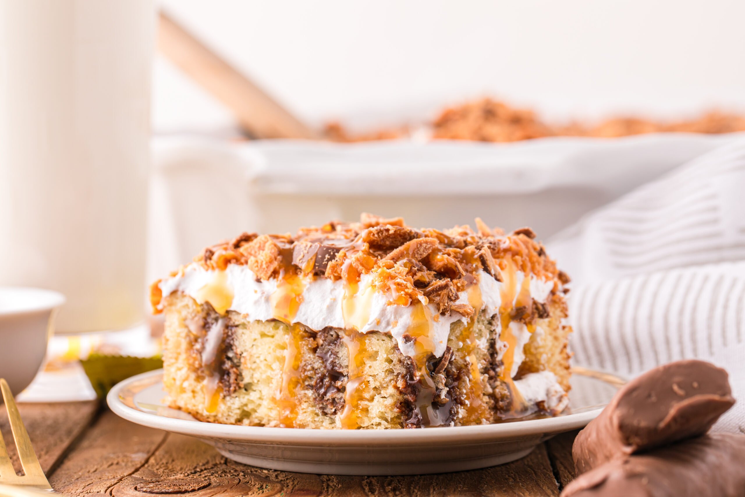 Butterfinger Poke Cake on a white plate 