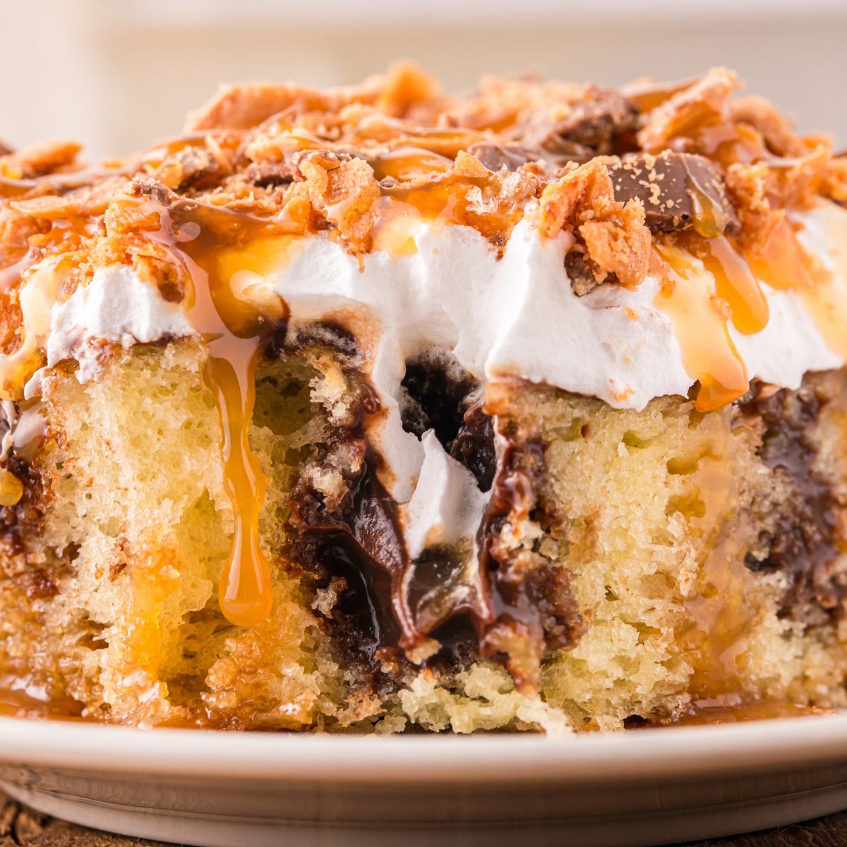 Butterfinger Poke Cake on plate with a bite taken out of it