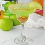 Caramel Apple Margarita on table with apples behind it