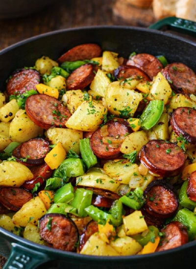 Sausage Peppers and Potatoes in a green skillet