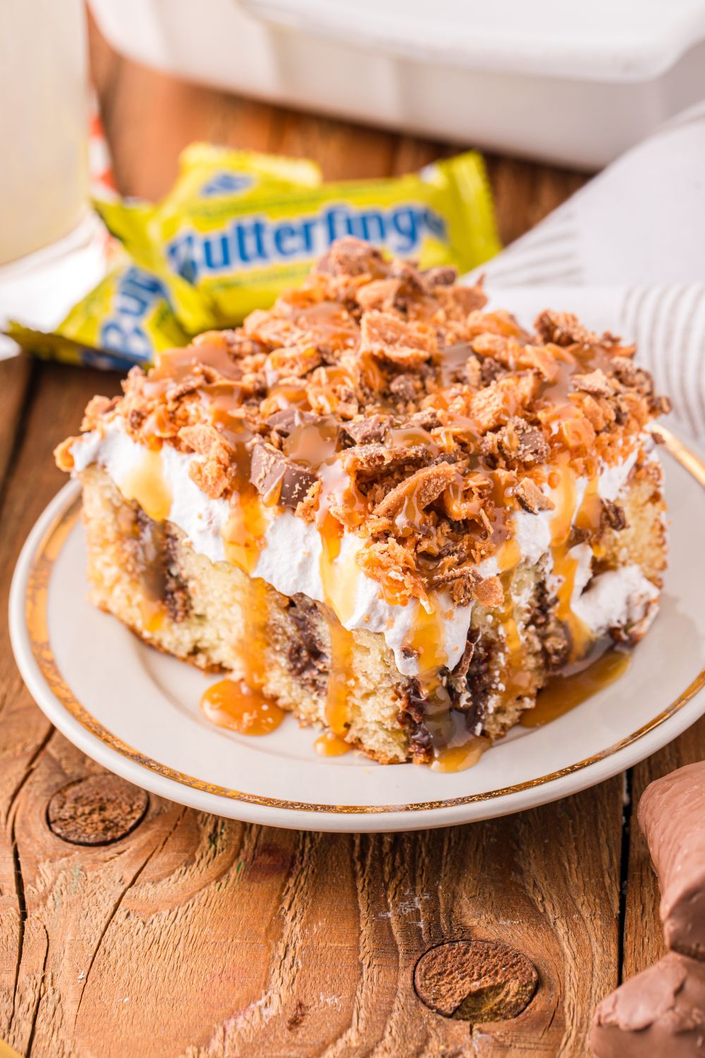 slice of cake on plate with butterfinger candy bars in the back