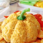 Pumpkin Shaped Cheeseball on platter with veggies and crackers around it