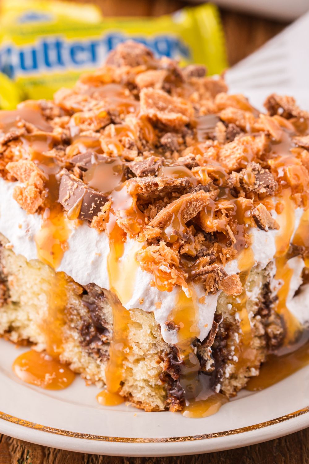 slice of cake on a plate with butterfinger candies in the background