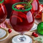 Christmas Sangria in glasses on table with cranberries and decorations around it