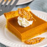 slice of pumpkin pie on plate with whipped cream