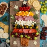 Christmas Tree Charcuterie Board on table with food around it