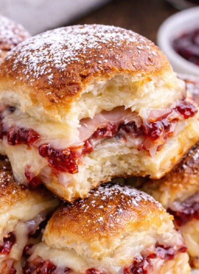 Monte Cristo Sliders on a white plate with a bite missing from the top one