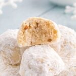 Snowball Cookies on table with one that has a bite taken out of it
