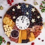 New Year's Eve Charcuterie Board on table with some garnishments around the charcuterie board