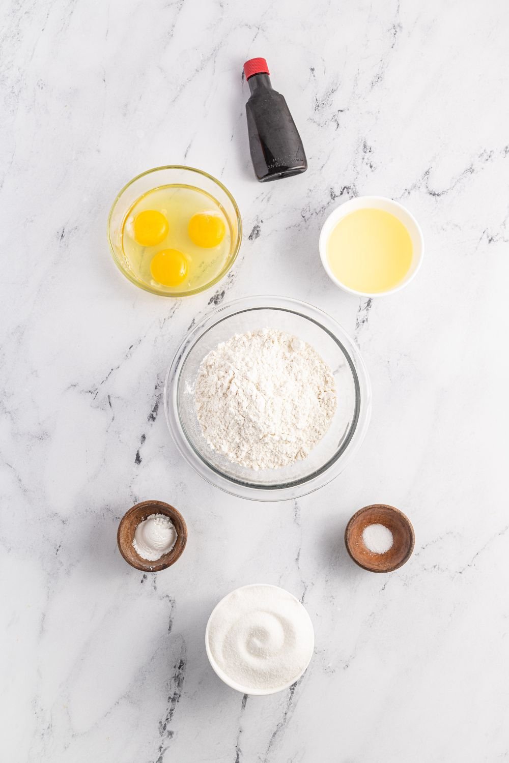 ingredients to make Pizzelles cookies on a marble counter 