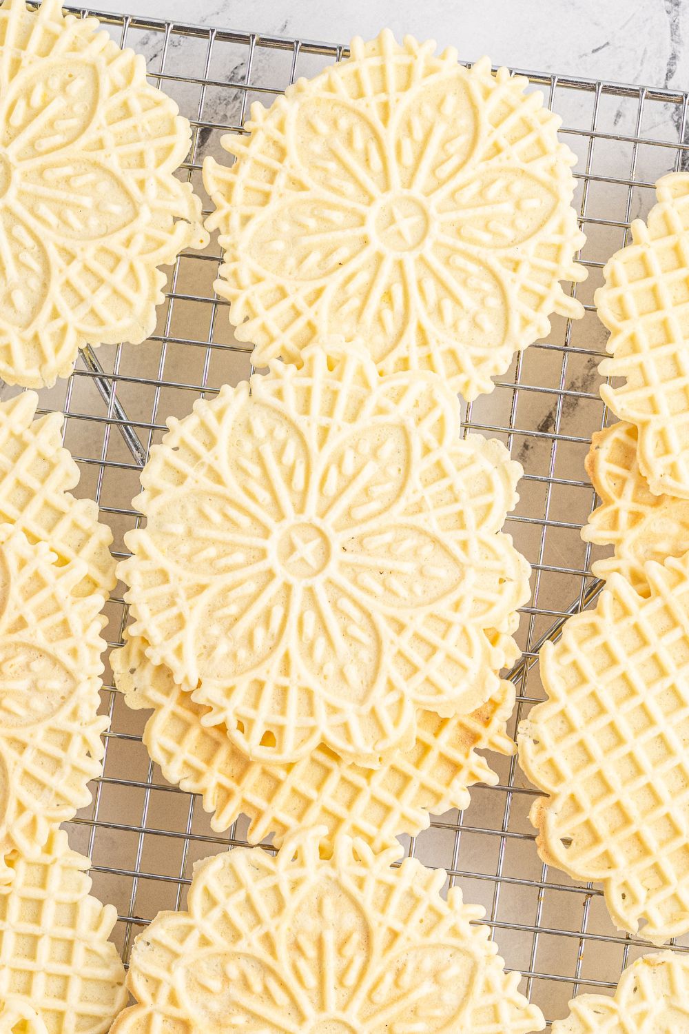 Pizzelle cookies stacked on a cooling rack 