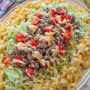 Big Mac Macaroni And Cheese on a platter with macaroni on bottom and Big Mac topper on top of the macaroni