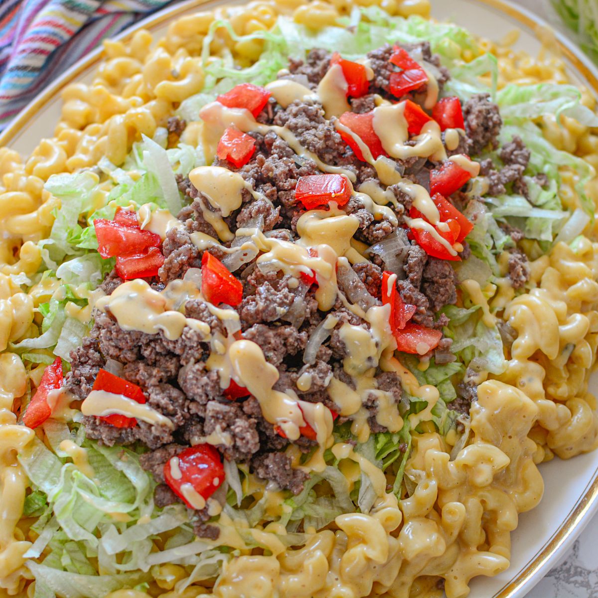Big Mac Macaroni And Cheese on a platter with macaroni on bottom and Big Mac topper on top of the macaroni 