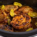 Crock Pot Mississippi Pork Chops in a crock pot with peppers on top of pork chops