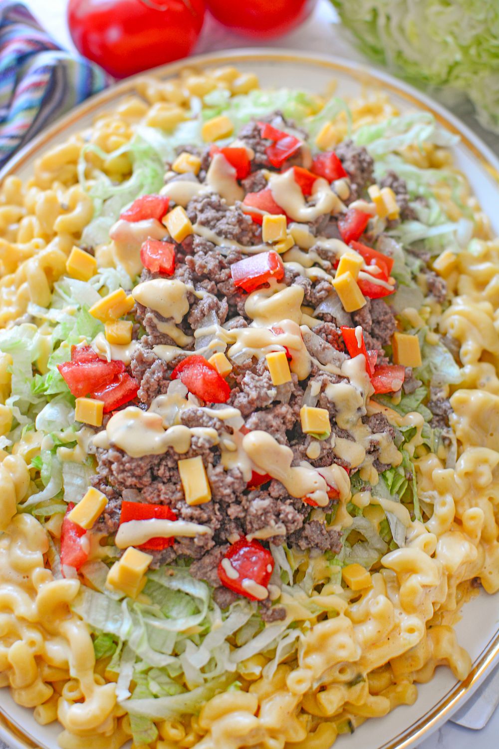 Big Mac Macaroni And Cheese on table with a bit of the ingredients around the platte r