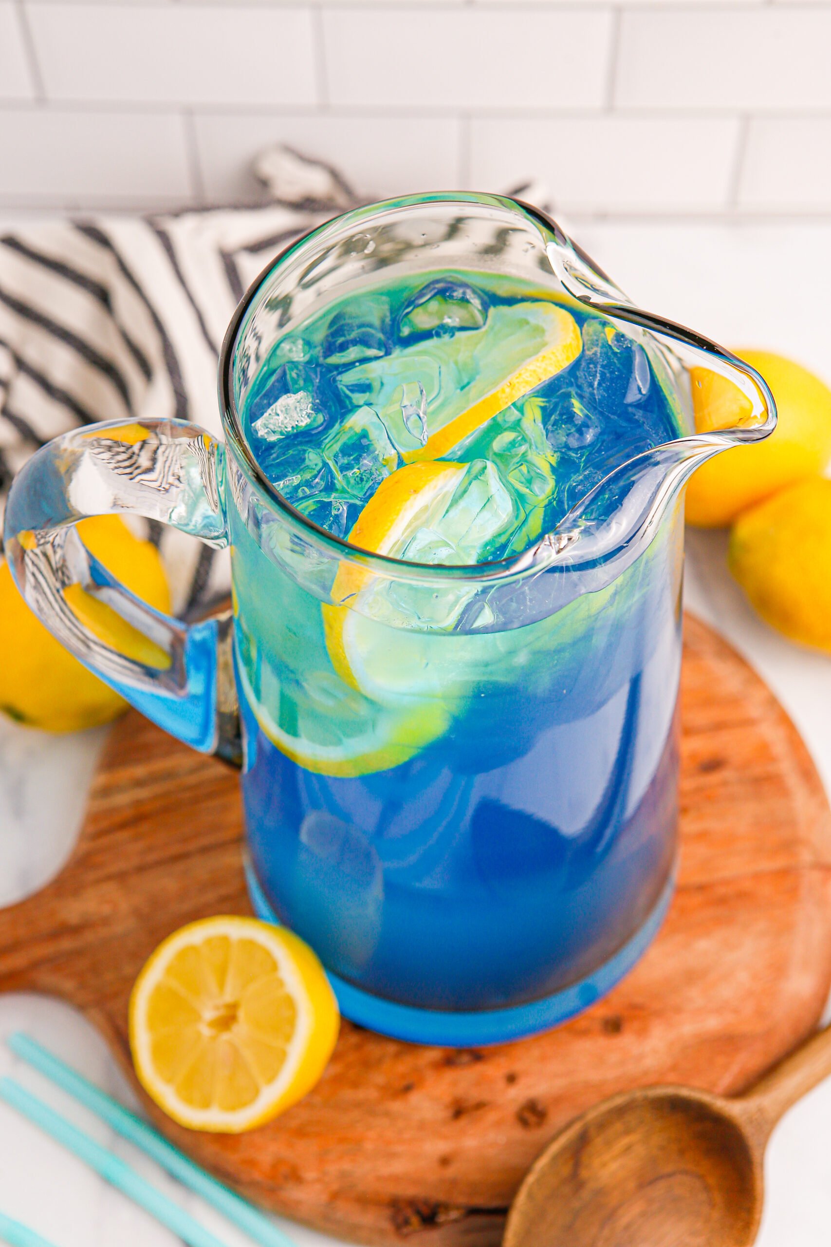 Blue Raspberry Lemonade in a pitcher with sliced lemons inside
