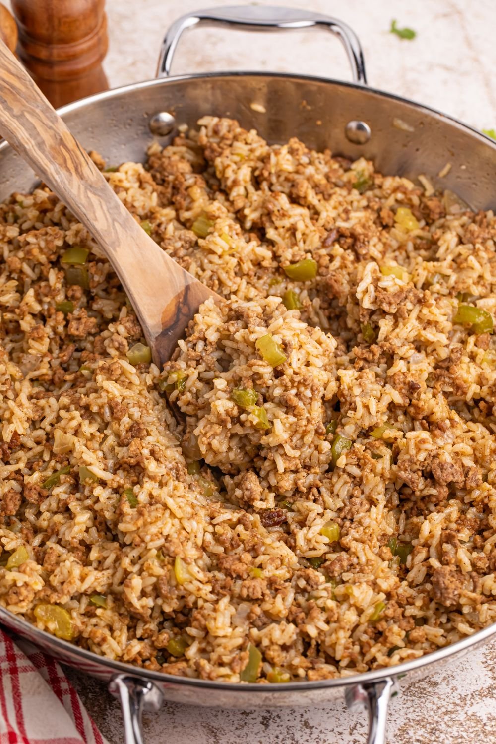 Dirty Rice in a pan with a spoon on the side of pan 