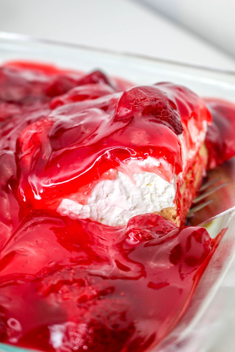 lifting a slice of No Bake Strawberry Delight out of pan 