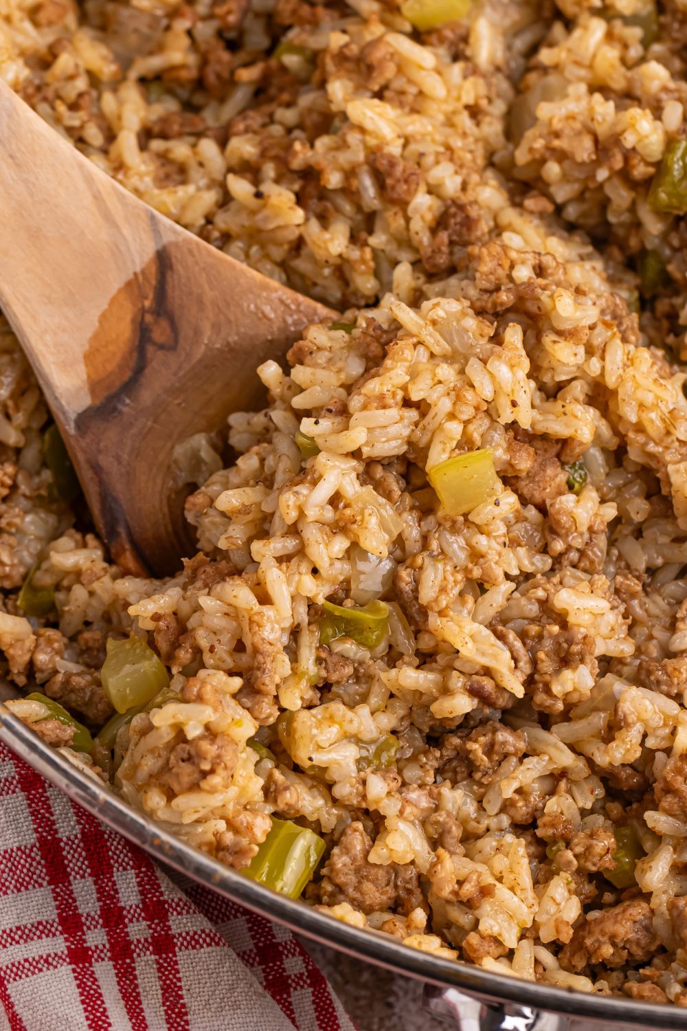 close up of Dirty Rice in a pan with a wooden spoon in it 