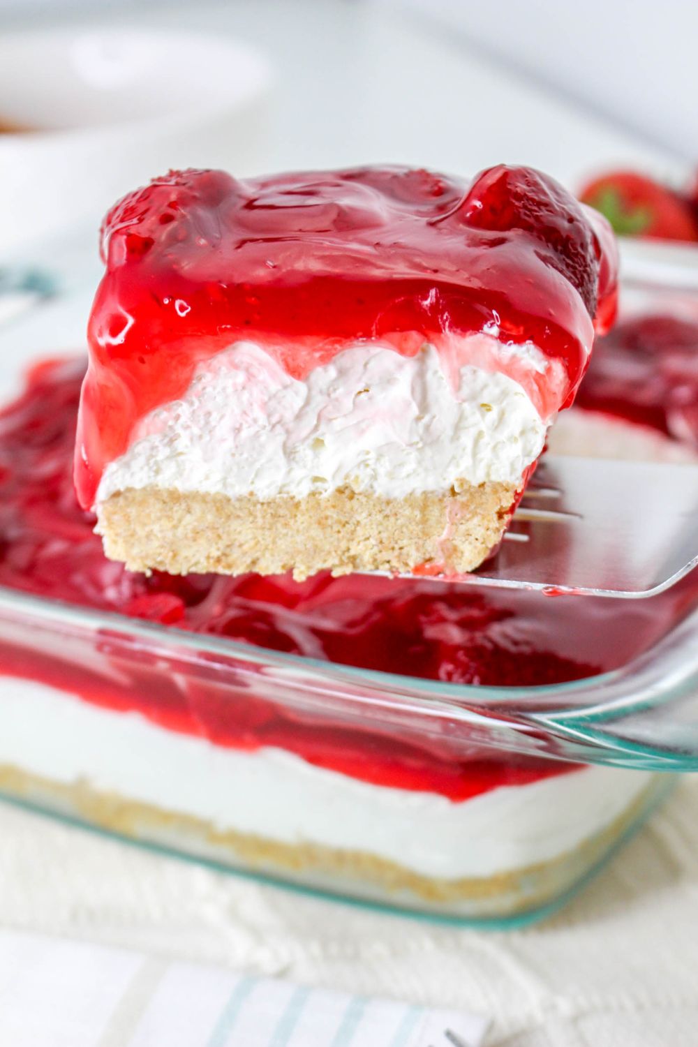 No Bake Strawberry Delight being lifted out of pan with spatula 