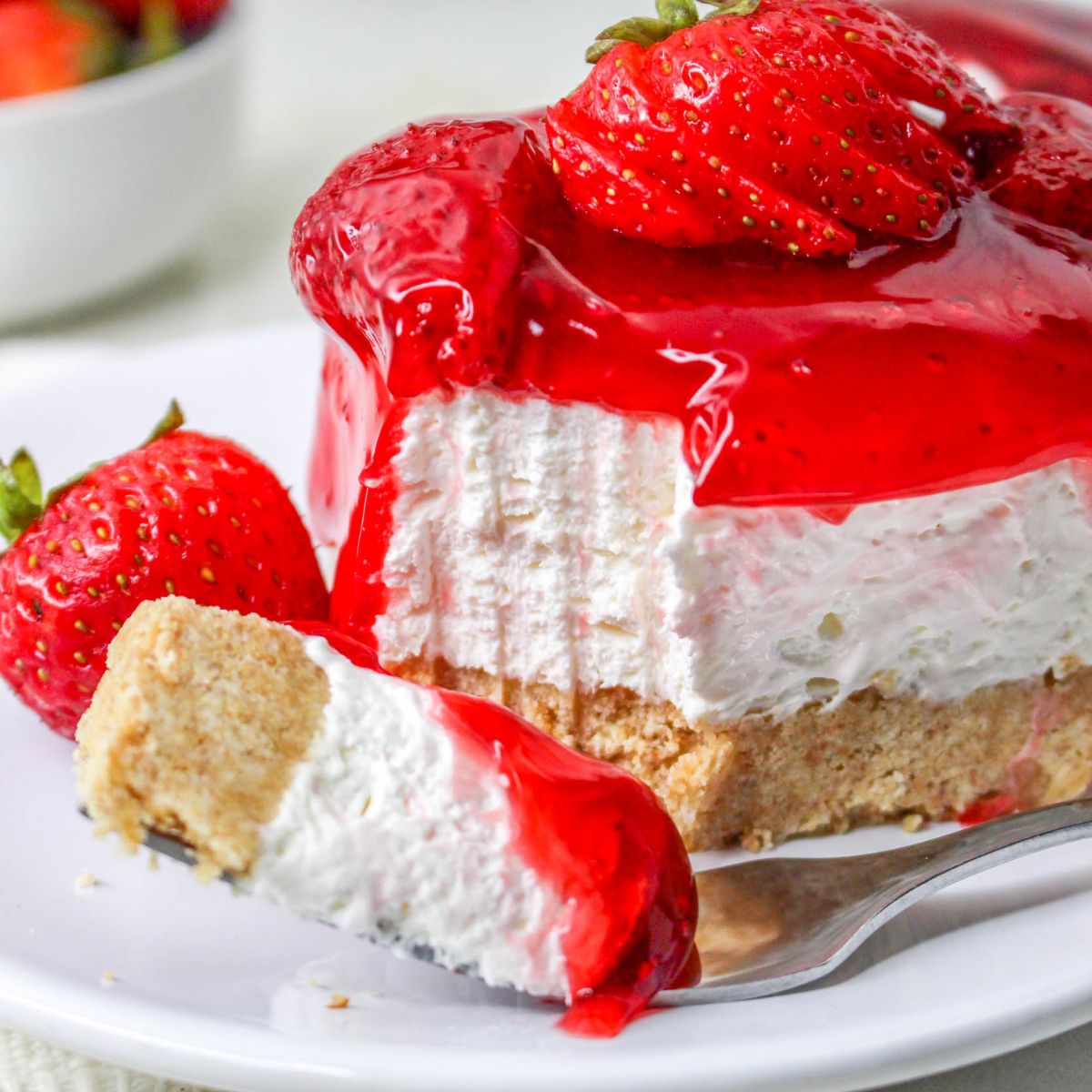No Bake Strawberry Delight on plate with a fork with a bite taken out of it