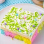 slice of Easter Poke Cake on a plat with napkin under the plate