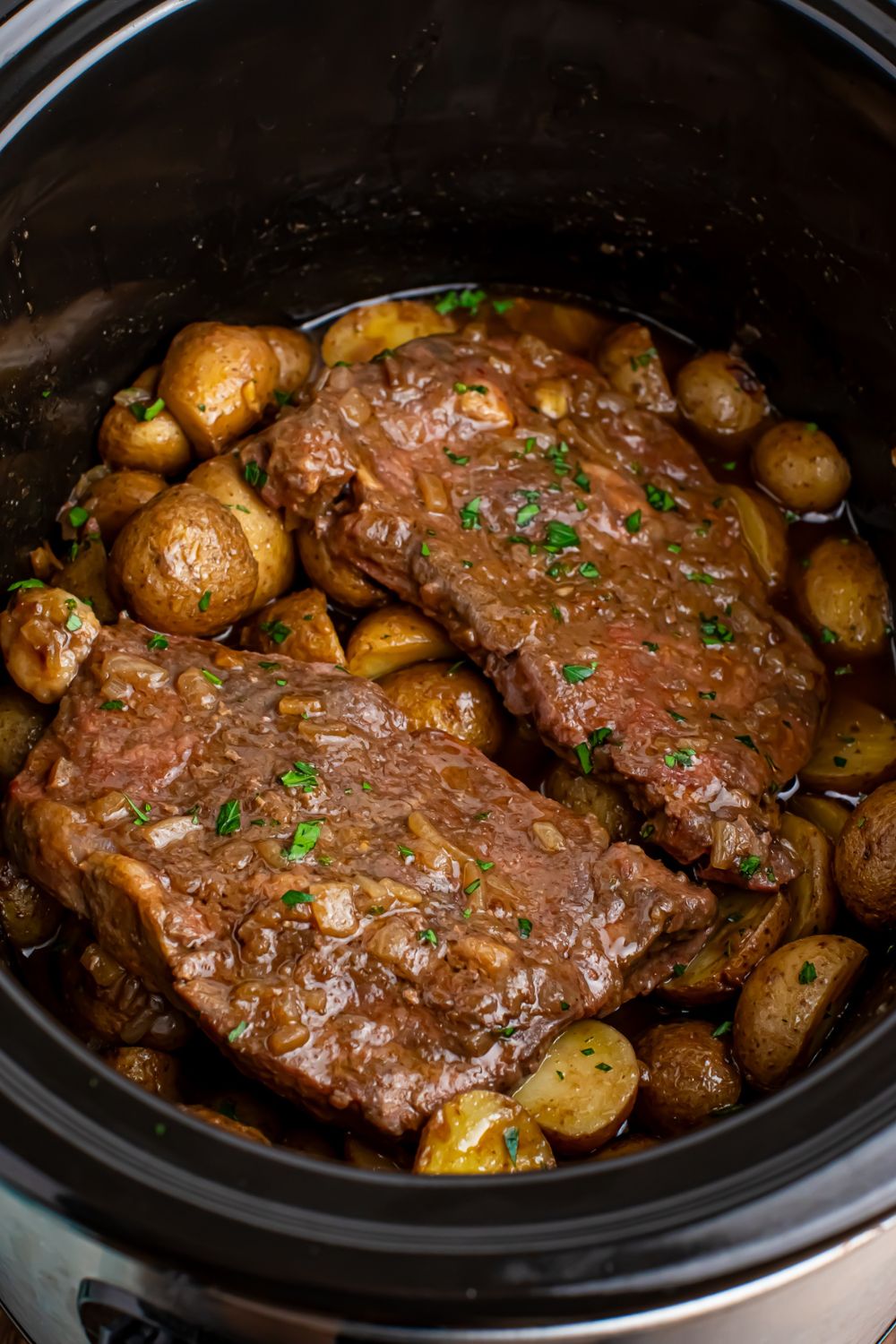 Crock Pot Steak and Potatoes in a crock pot sitting on a table 