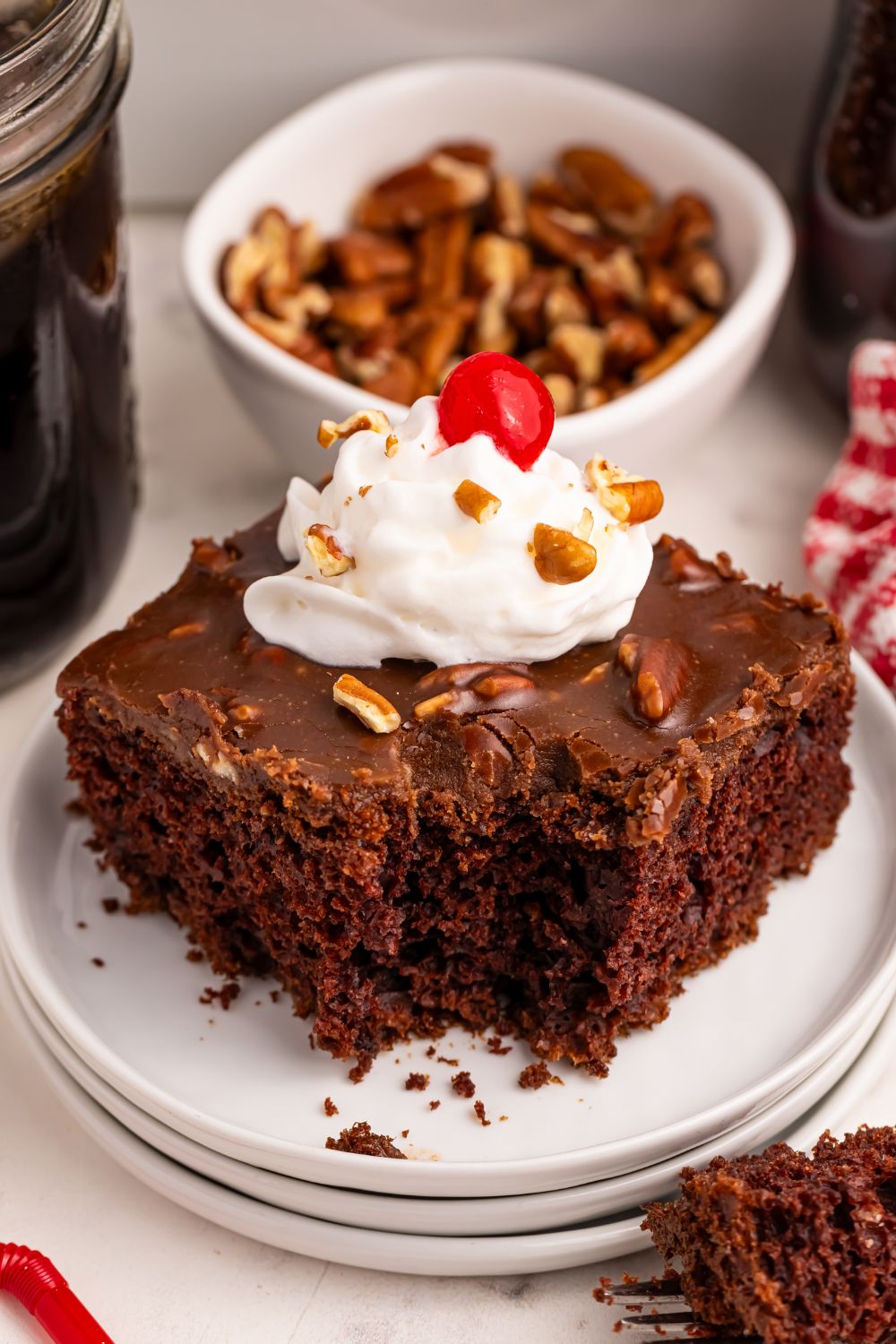 slice of cake on plate with whipped cream and cherry on top