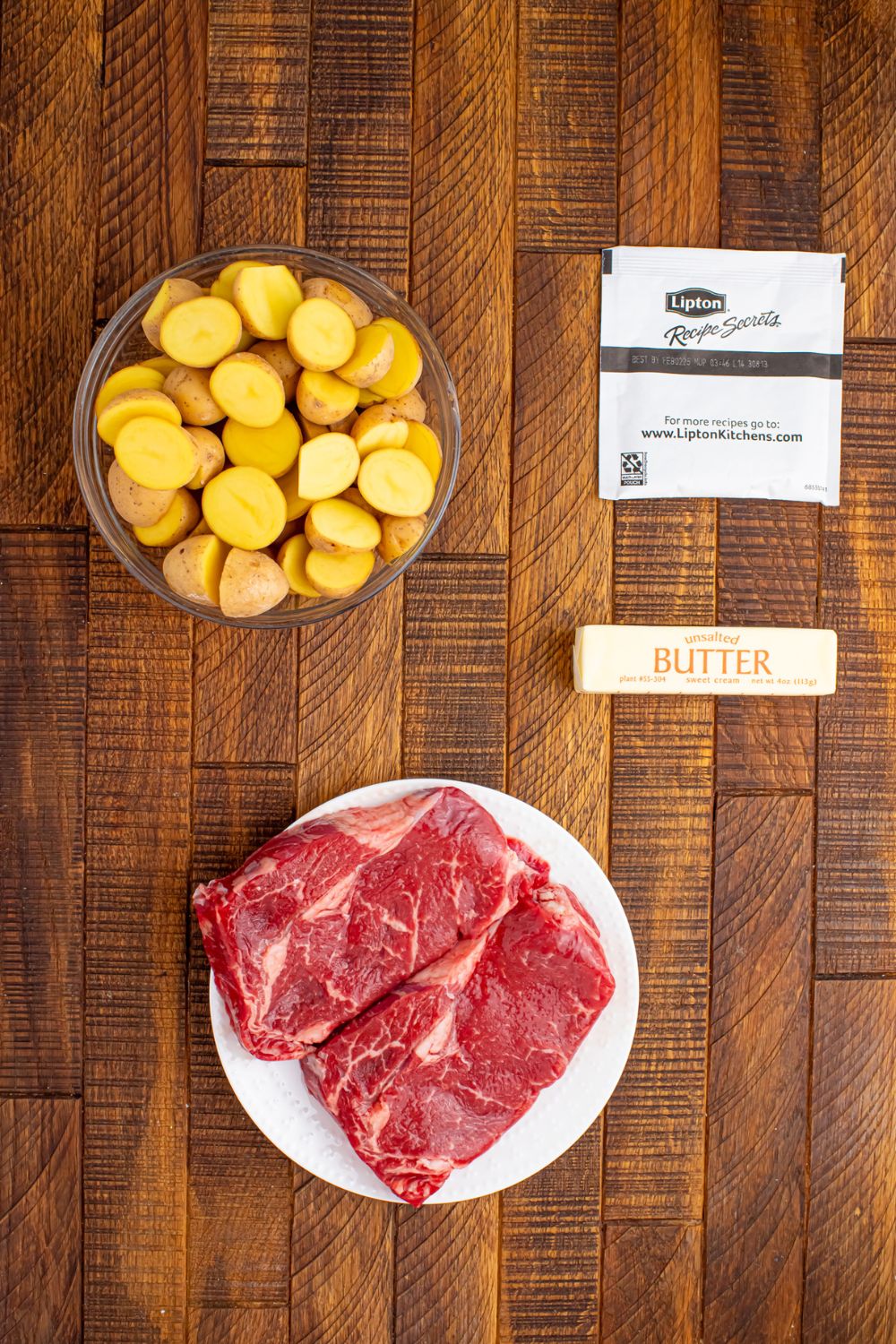 ingredients for Crock Pot Steak and Potatoes on a wooden table 