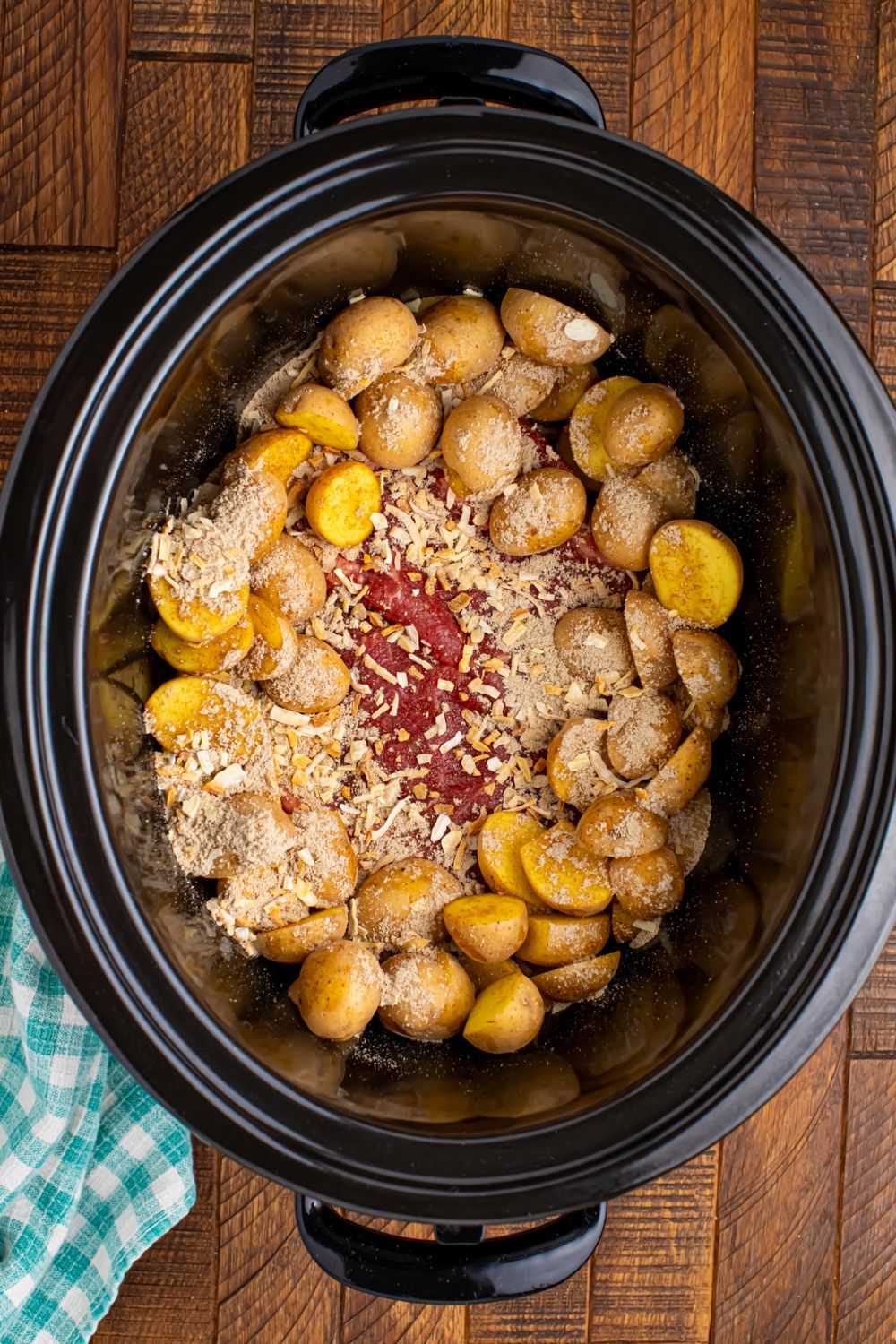 seasoning sprinkled over he potatoes and steak for Crock Pot Steak and Potatoes
