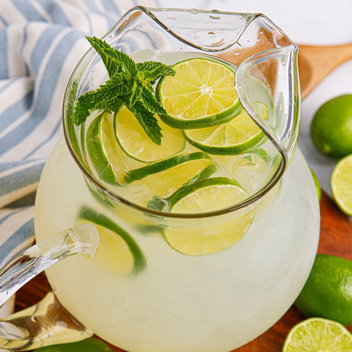 Limeade in a pitcher topped with sliced limes and mint leaves 