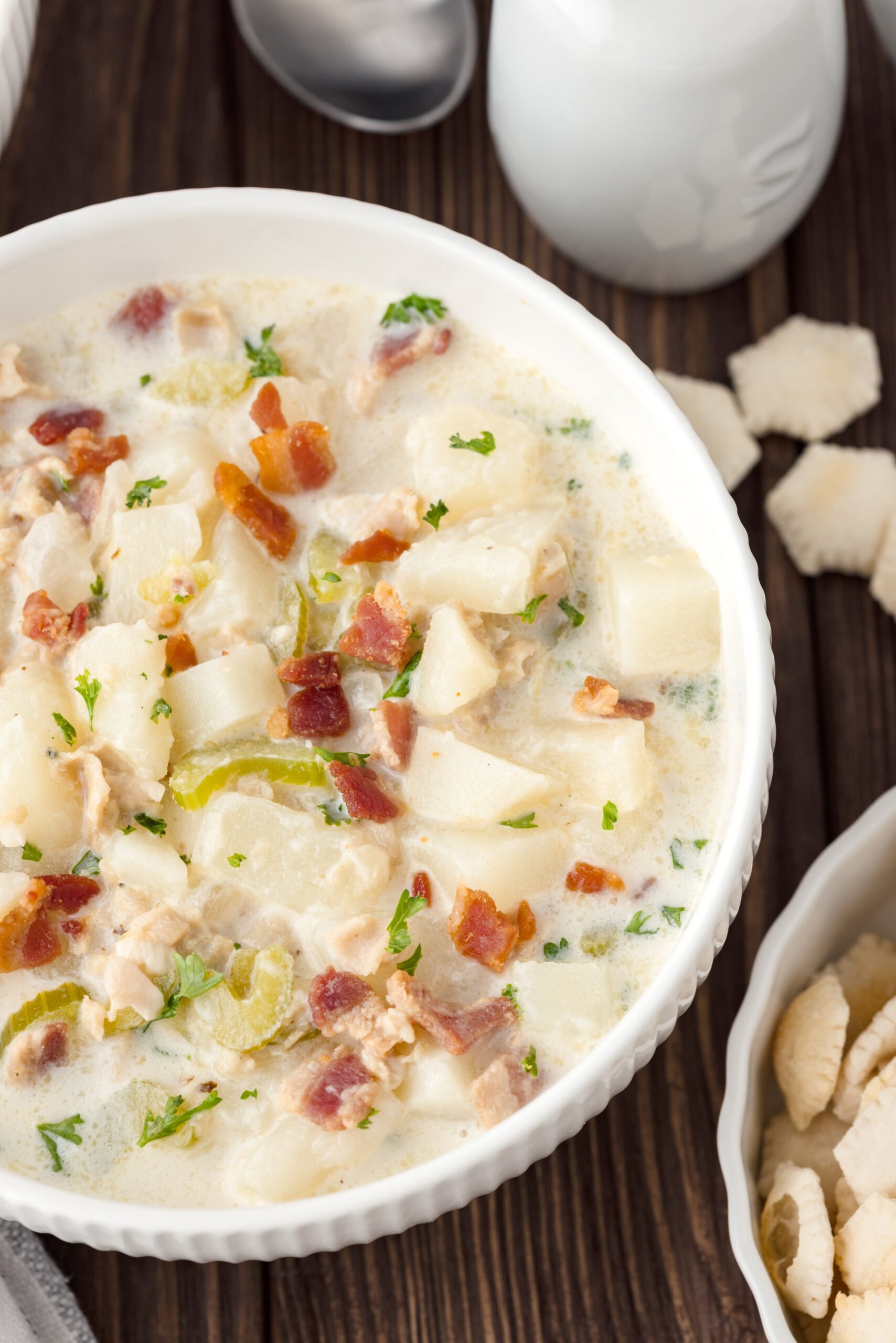 Bowl of Clam Chowder with oyster cracks next to it 