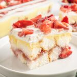 Strawberry Heaven On Earth Cake on a small plate with the whole dessert in pan behind it