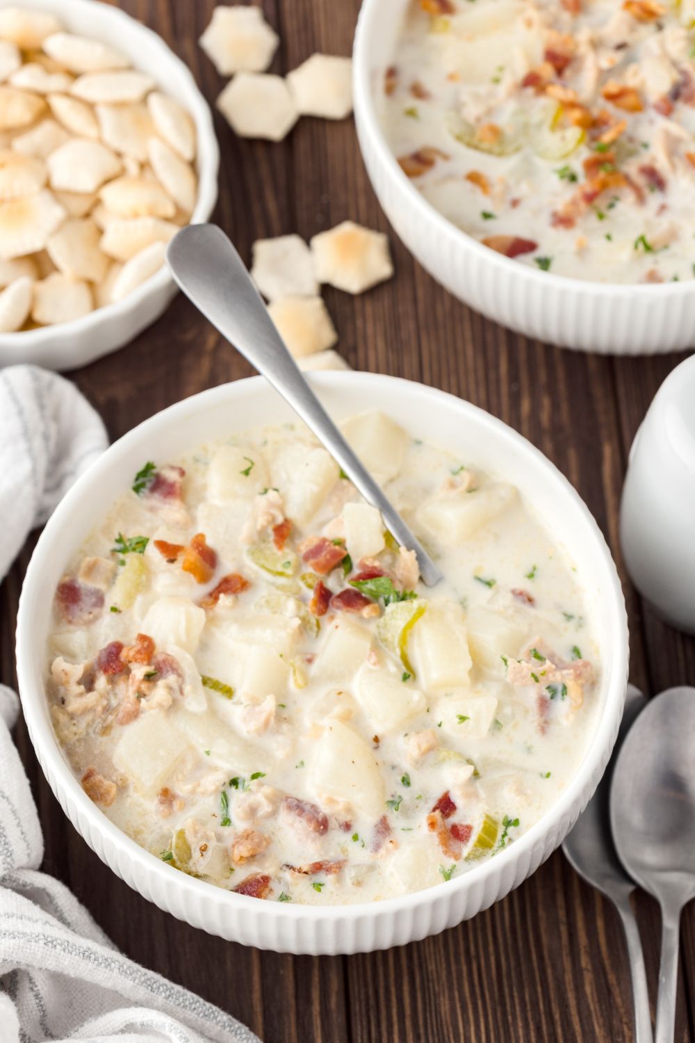 overhead look of table with clam chowder in bowls and a bowl of crackers