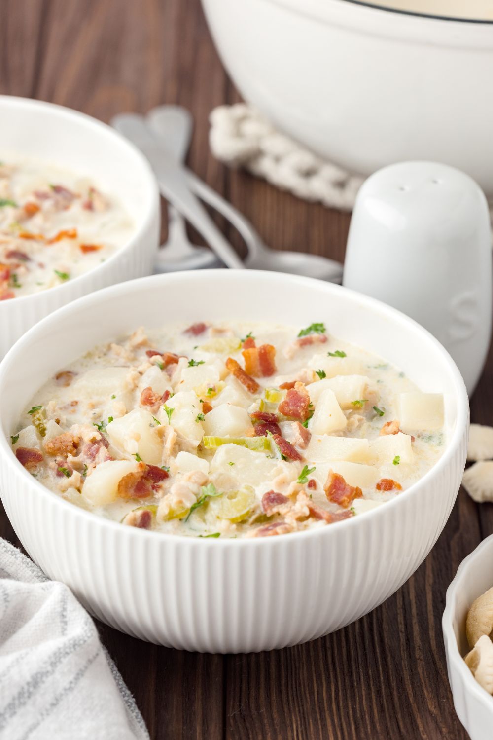 bowls New England Clam Chowder in bowls with salt and pepper shakers by it sitting on table 