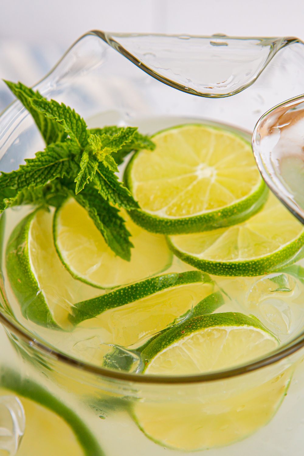 lime aid drink in a pitcher with mint and lime slices
