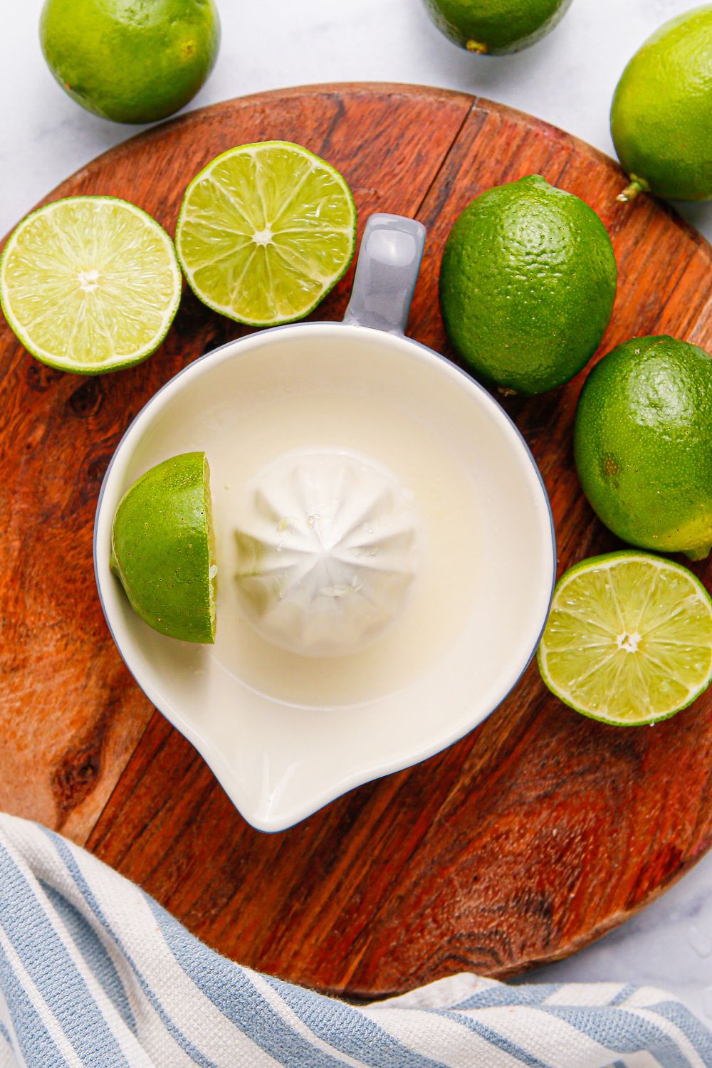 limes around table and a juicer showing limes being juiced
