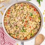 Philly Cheesesteak Pasta in a skillet on table with spoon beside pan