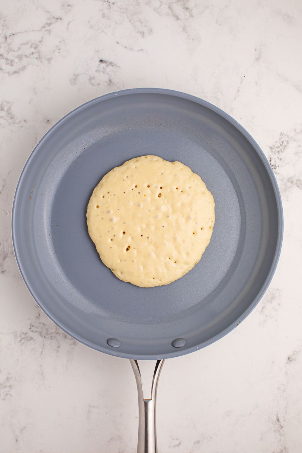 pancake in a skillet that is uncooked 