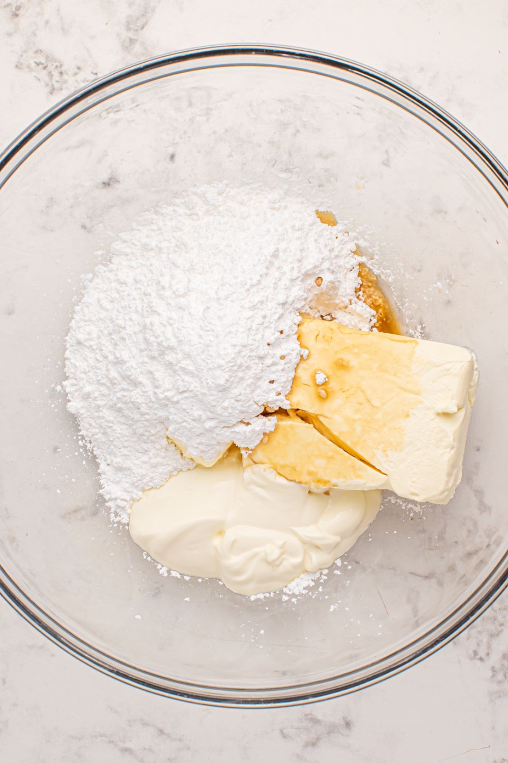 cheesecake mixture for strawberry cheesecake pancakes in a glass bowl on marble counter