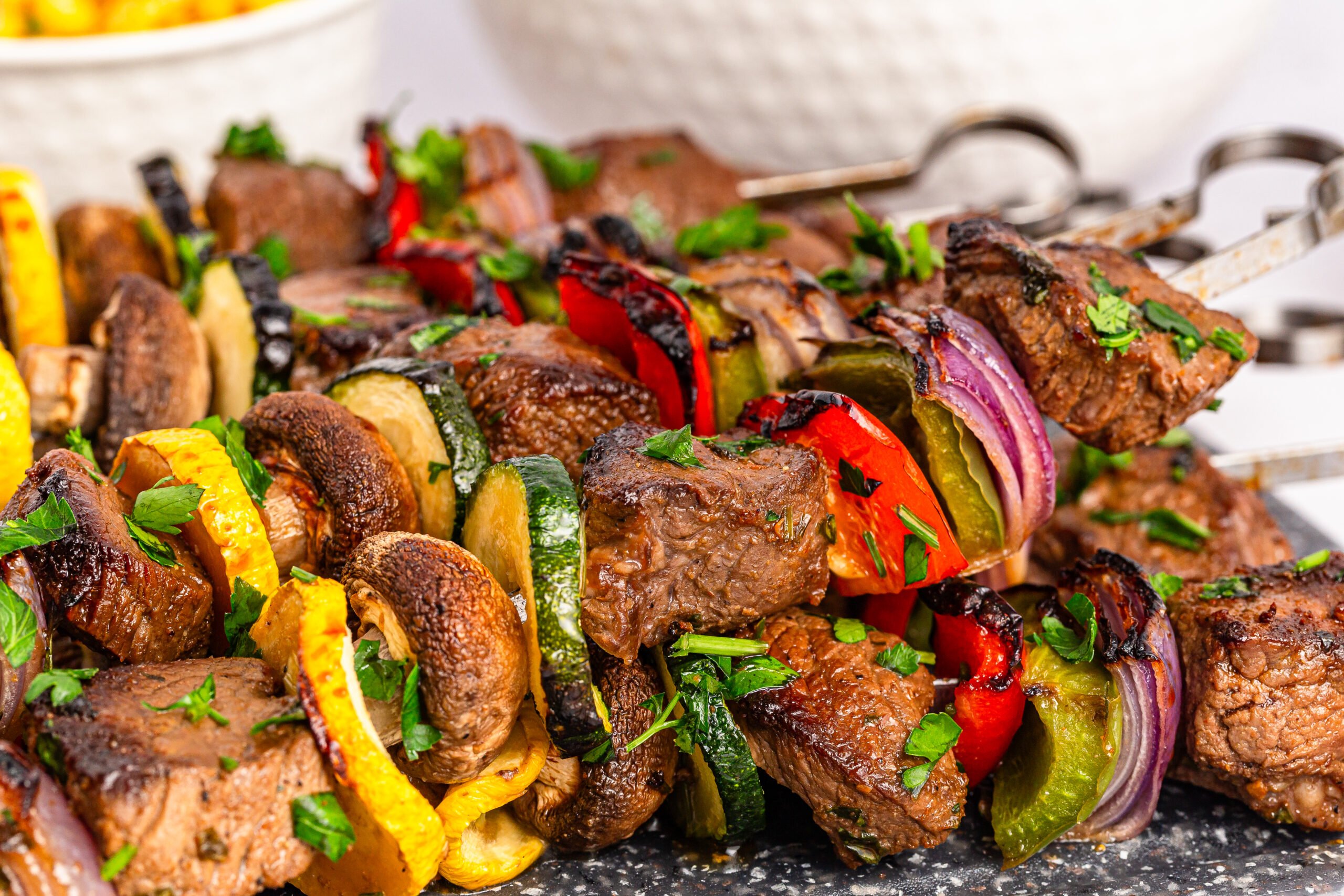 Marinated Beef Kabobs stacked on top of each other on a tray 