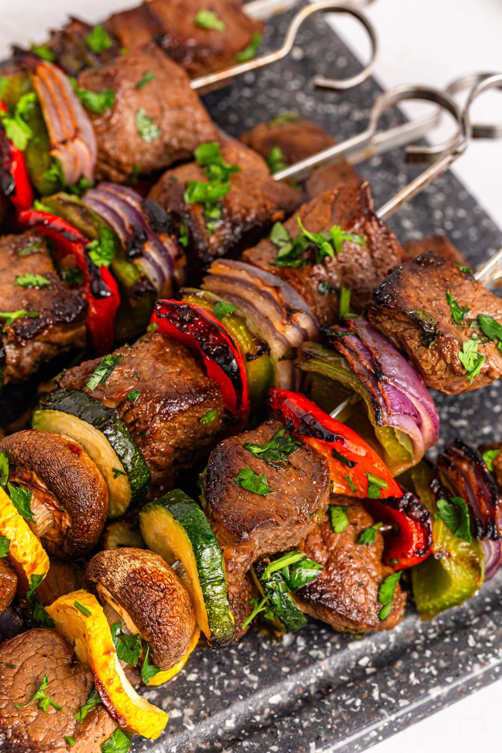 Marinated Beef Kabobs on a metal tray sitting on a table 