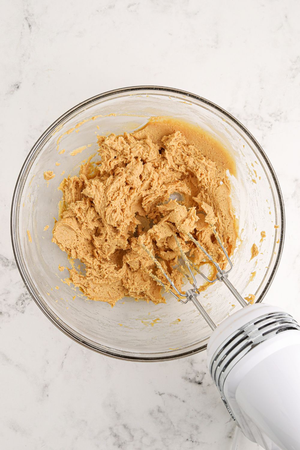 glass bowl with peanut butter mixture being mixed up for the Reeses Lasagna