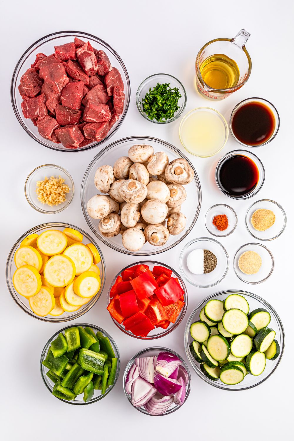 all the ingredients to make these Marinated Beef Kabobs sitting in glass bowls on a counter