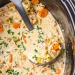 Slow Cooker Turkey And Rice Soup in a slow cooker with a large ladle in slow cooker