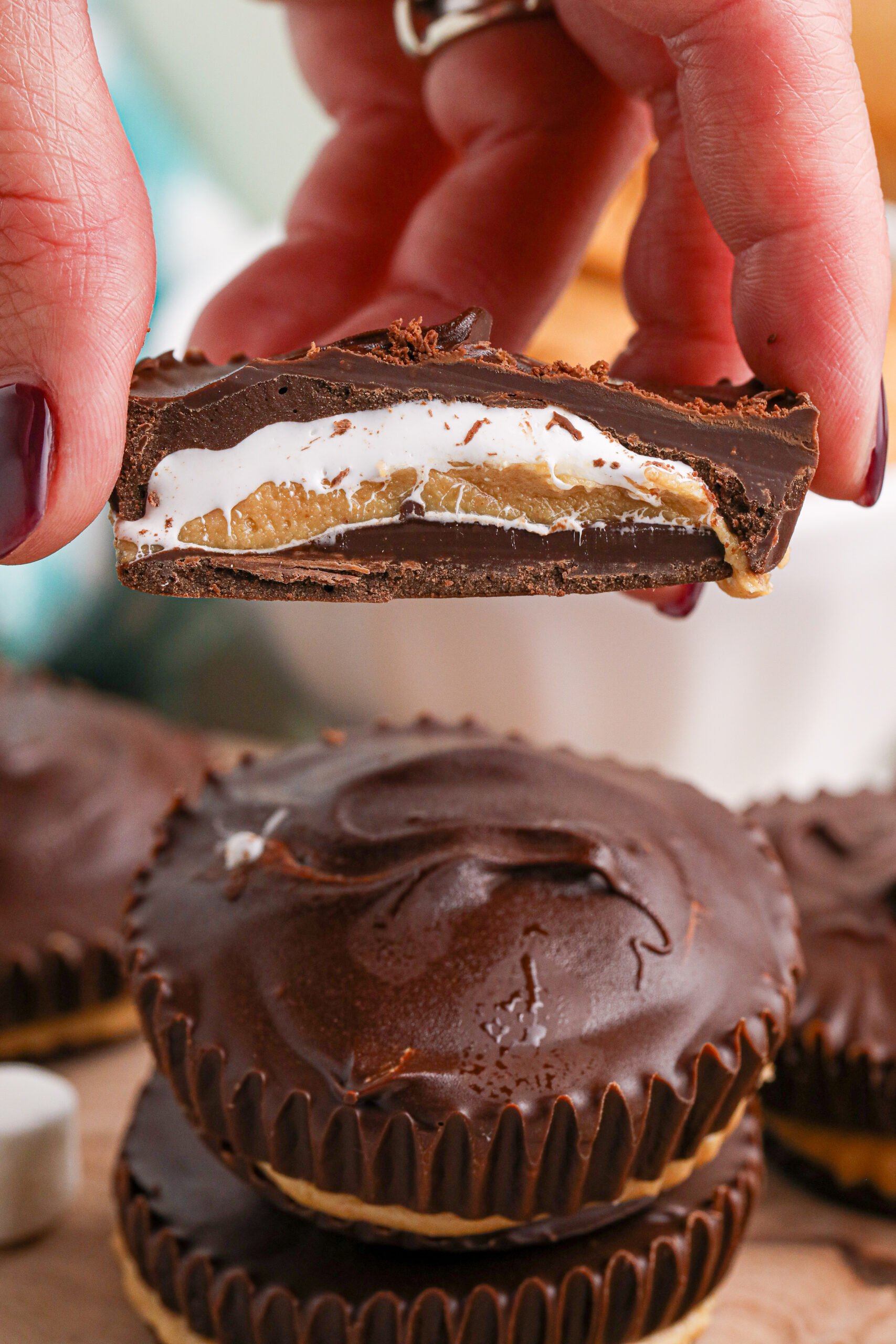 Hand holding a cut open marshmallow peanut butter cup showing the inside 