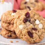 White Chocolate Cranberry Oatmeal Cookies stacked on a plate with one tilted to see cranberries and white chocolate chips on it